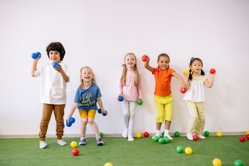 Kinder spielen mit Bällen Kindergartenfotografie
